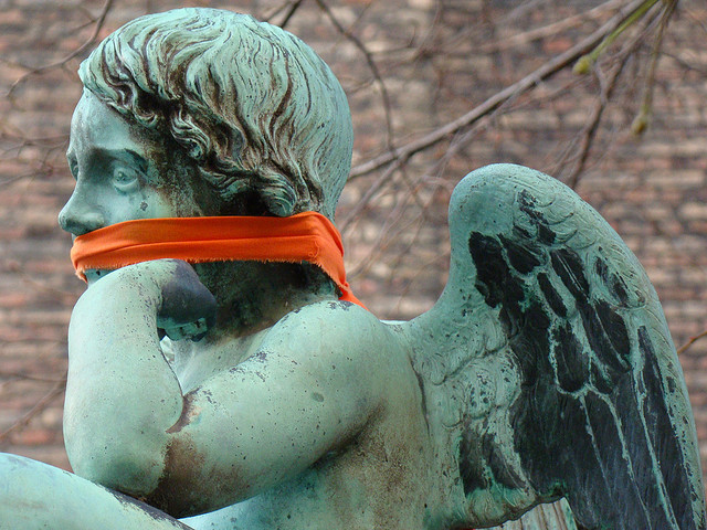 Photo of a cherub statue with cloth tied around its mouth