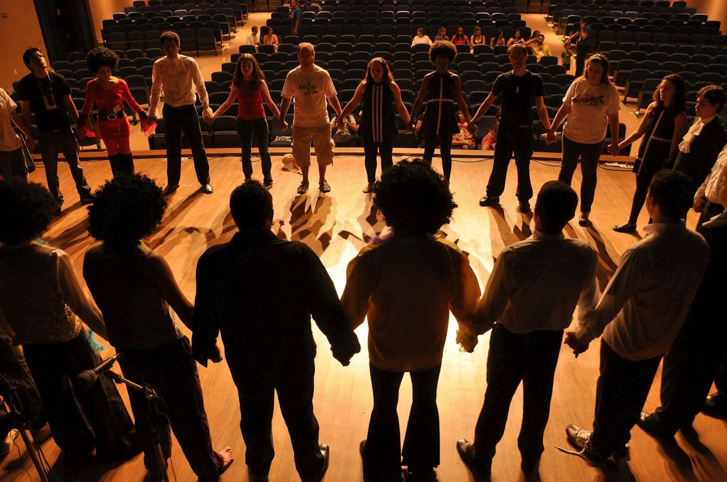 Photo of people on stage holding hands