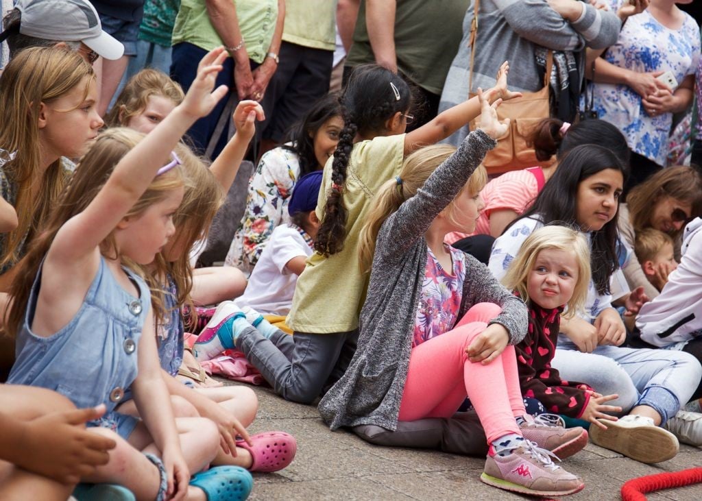 Photo of children sitting outside on ground