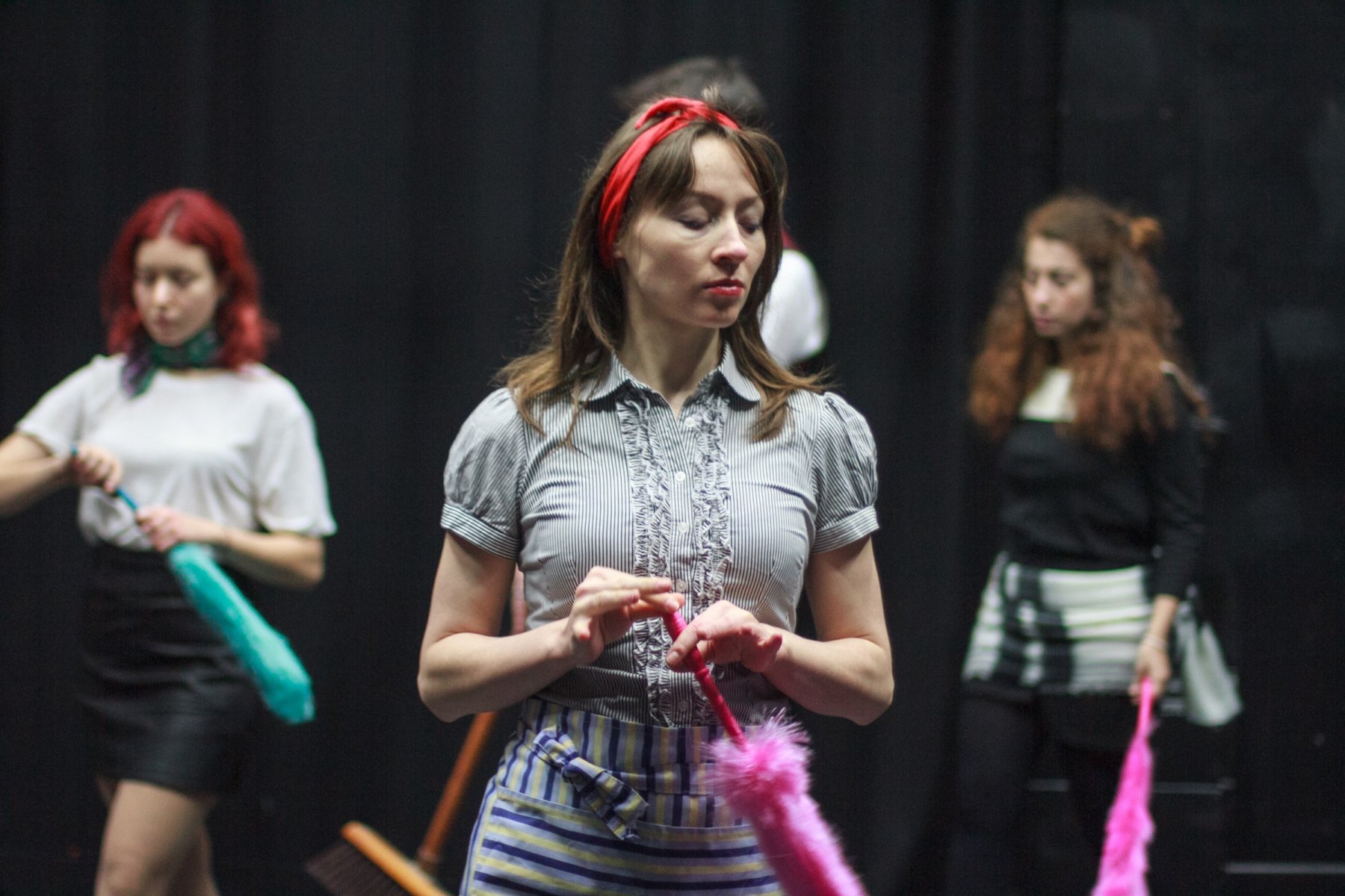 Photo of three wowen in stage production holding dusters