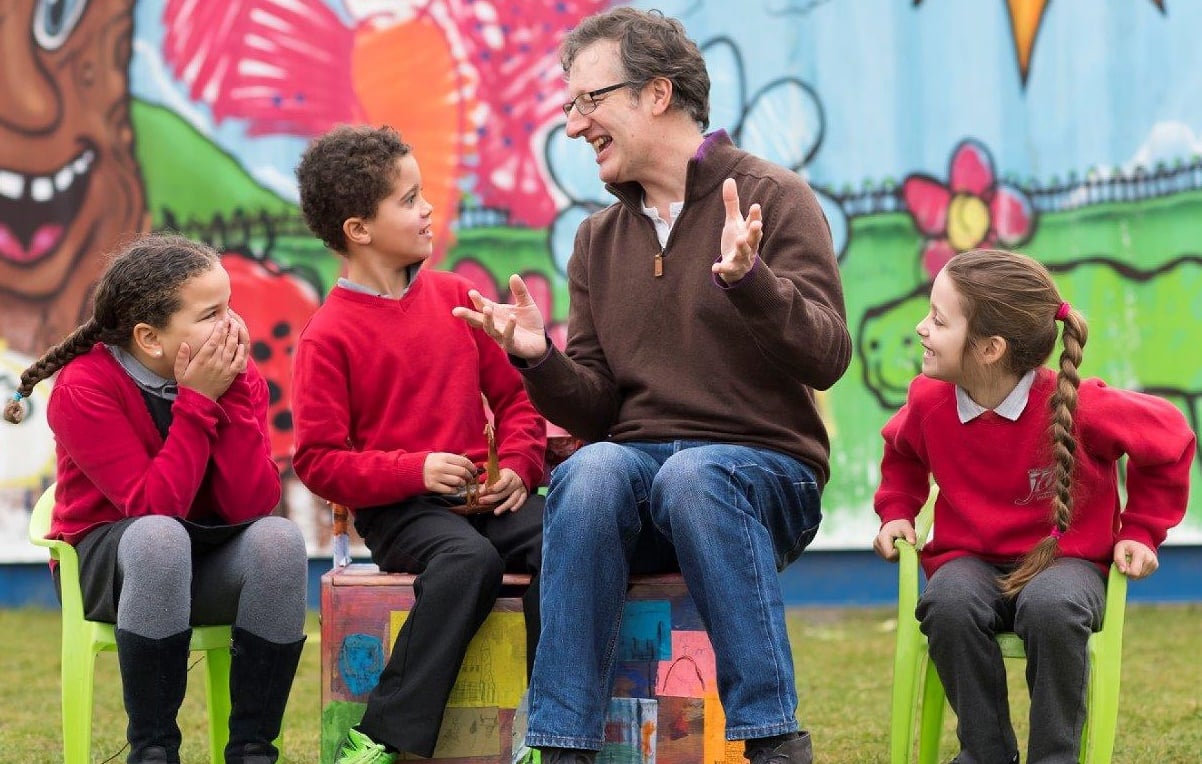 Man making schoolchildren laugh