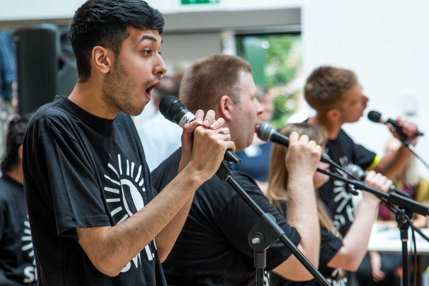 Photo of three young men singing with microphones