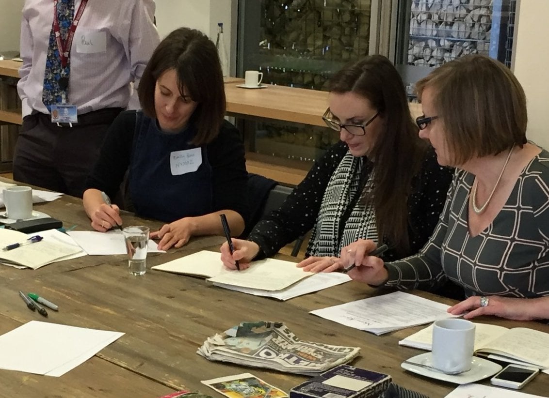 Photo of three women writing at a table