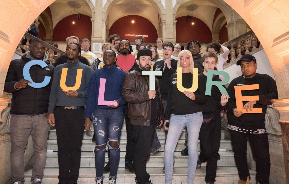 Photo of a group of people holding individual letters to spell out 