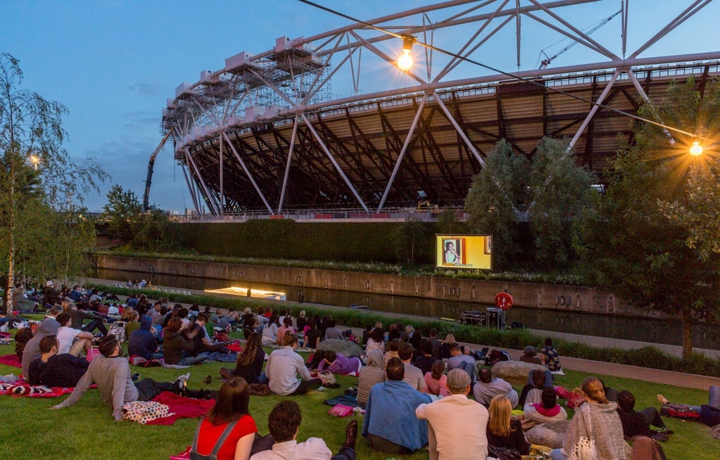 People watching a film outside next to a canal