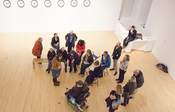 A photo of visitors in an art gallery, including a wheelchair user