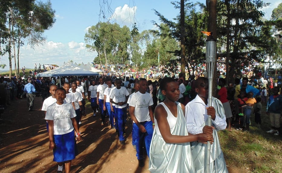 A photo of a procession of young people holding a flame