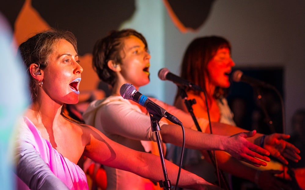 A photo of three women singing