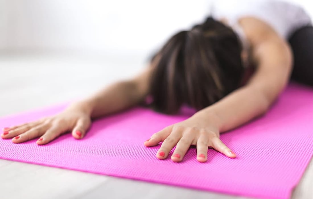 A woman stretching on a yoga mat