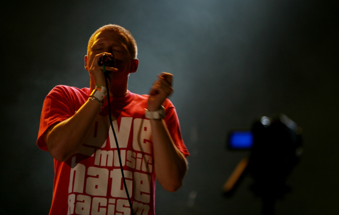 Man singing and wearing t-shirt saying 'love music hate racism'