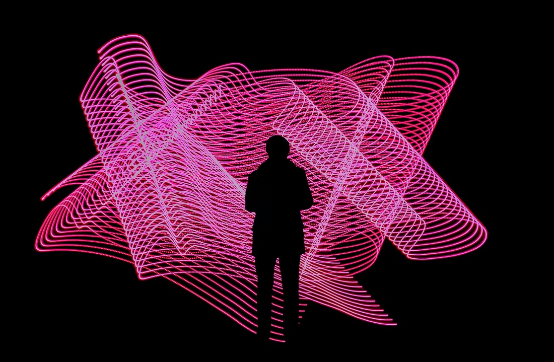 Silhouette of a person in front of a neon pink light display