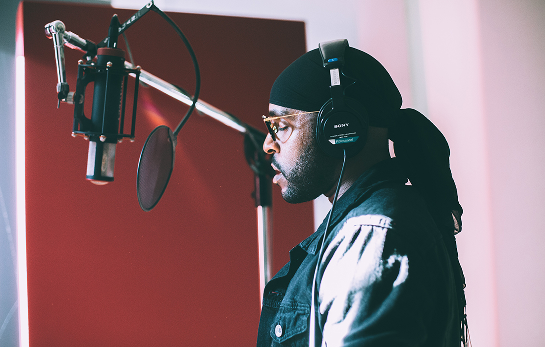 A man singing into a microphone in a studio