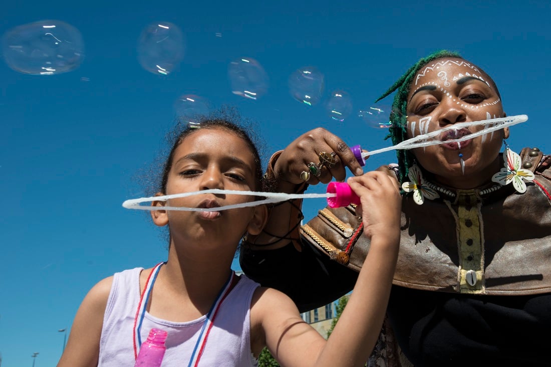 Two young people blowing bubbles into a camera