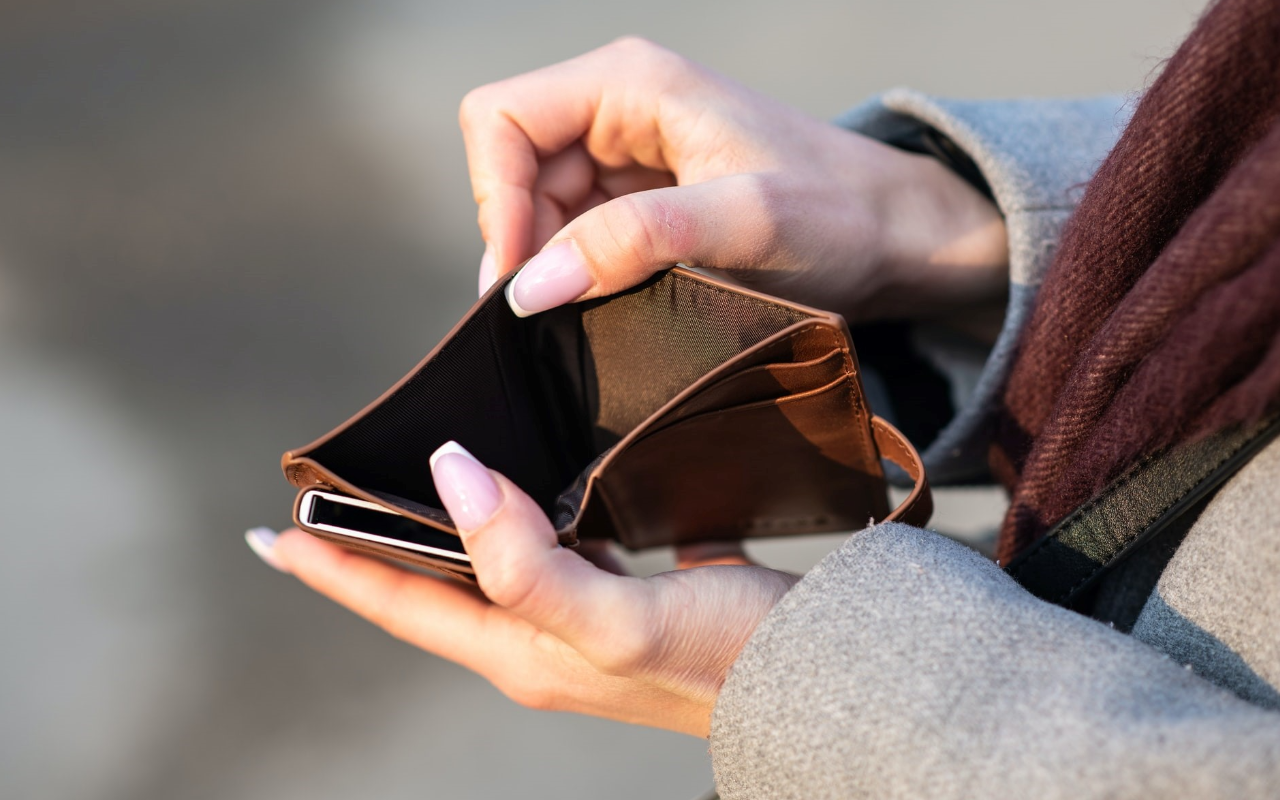 a close up image of hands opening an empty wallet