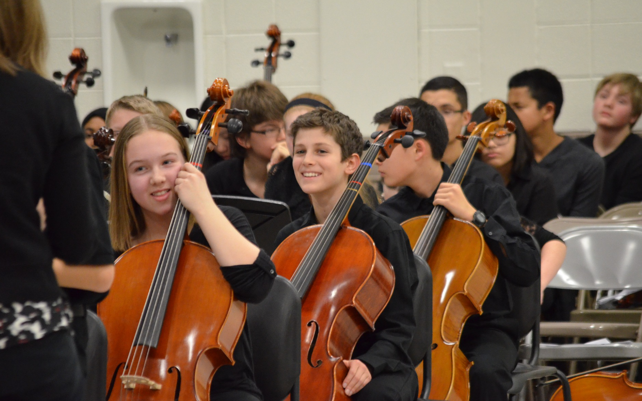 a group of students play the cello