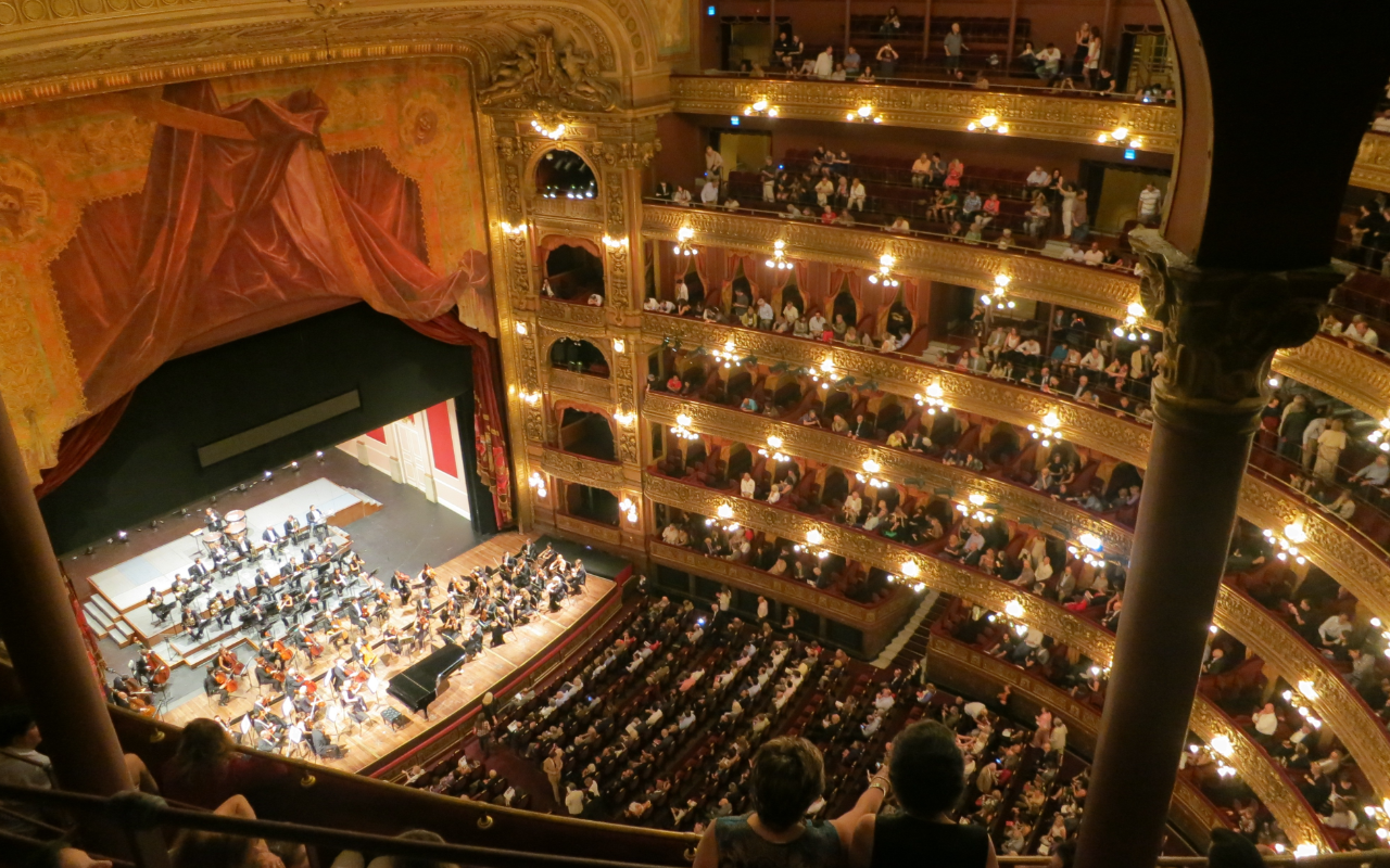 an audience watches an orchestra in an auditorium