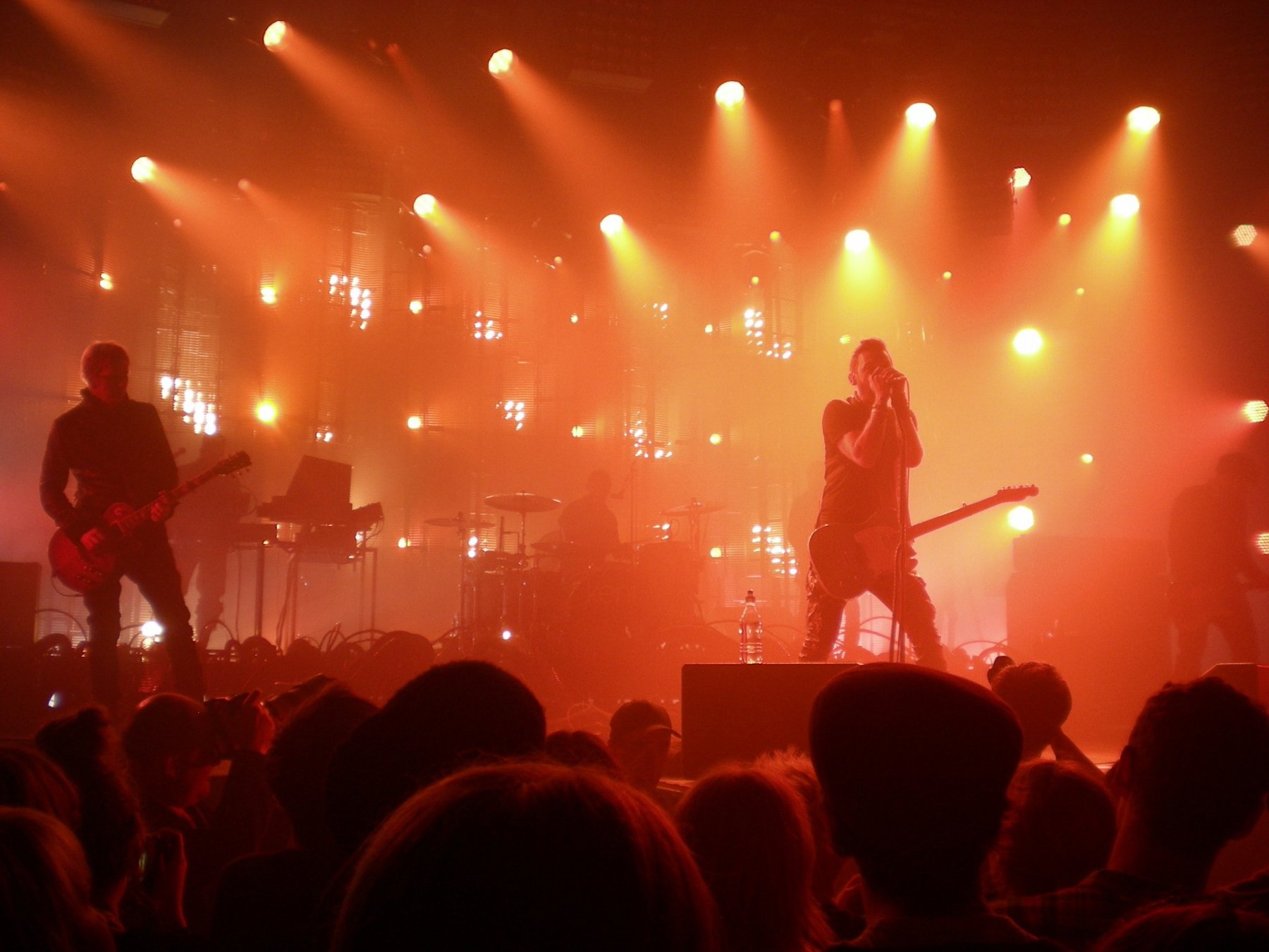 Musicians performing under lights in venue