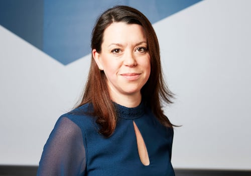 Sophie Jones is smiling at the camera. She has shoulder-length brown hair and is wearing a blue top