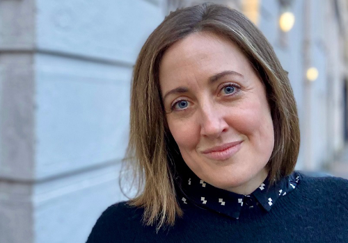 Liz King has light brown hair and is smiling at the camera.