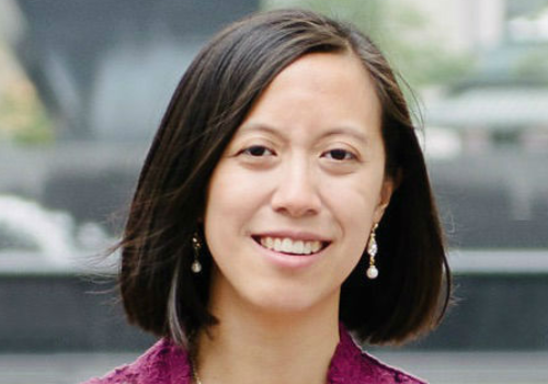 Melissa Wong, incoming Director of Programmes, Arts Emergency. Wong is an East Asian woman with short, brown hair. She is photographed outside, the background is blurred and she is smiling at the camera.