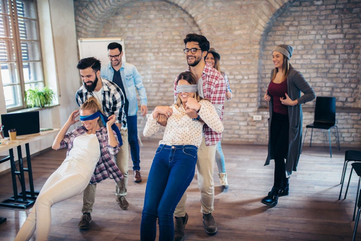 People playing a trust exercise, half of them blindfolded