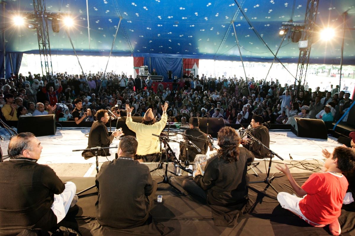 Qawwali group on stage with the audience in the background at London Mela