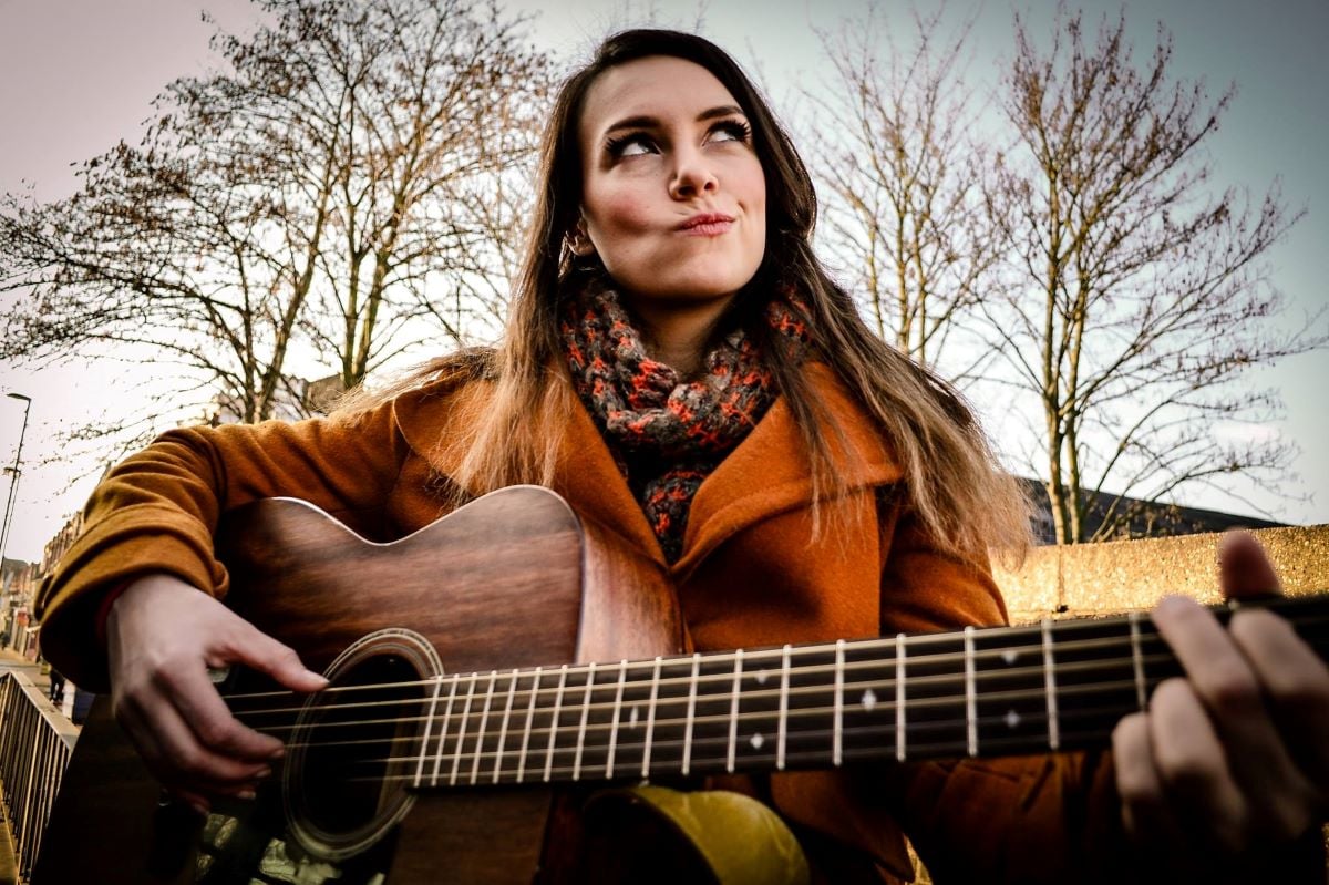 Musician Fiona Fey holding a guitar