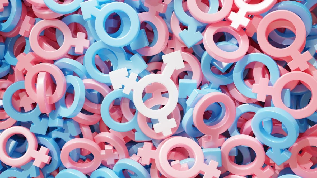 White transgender symbol on the background of many pink and blue gender symbols. The colours of the transgender flag. 3D illustration via iStock.