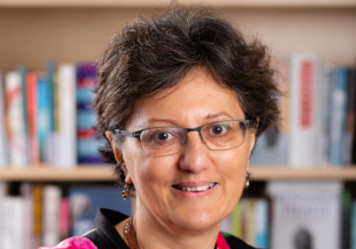 Nicola Solomon stood in front of a bookshelf