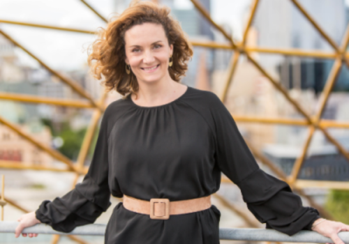 Claire Spencer smiles in front of a city backdrop