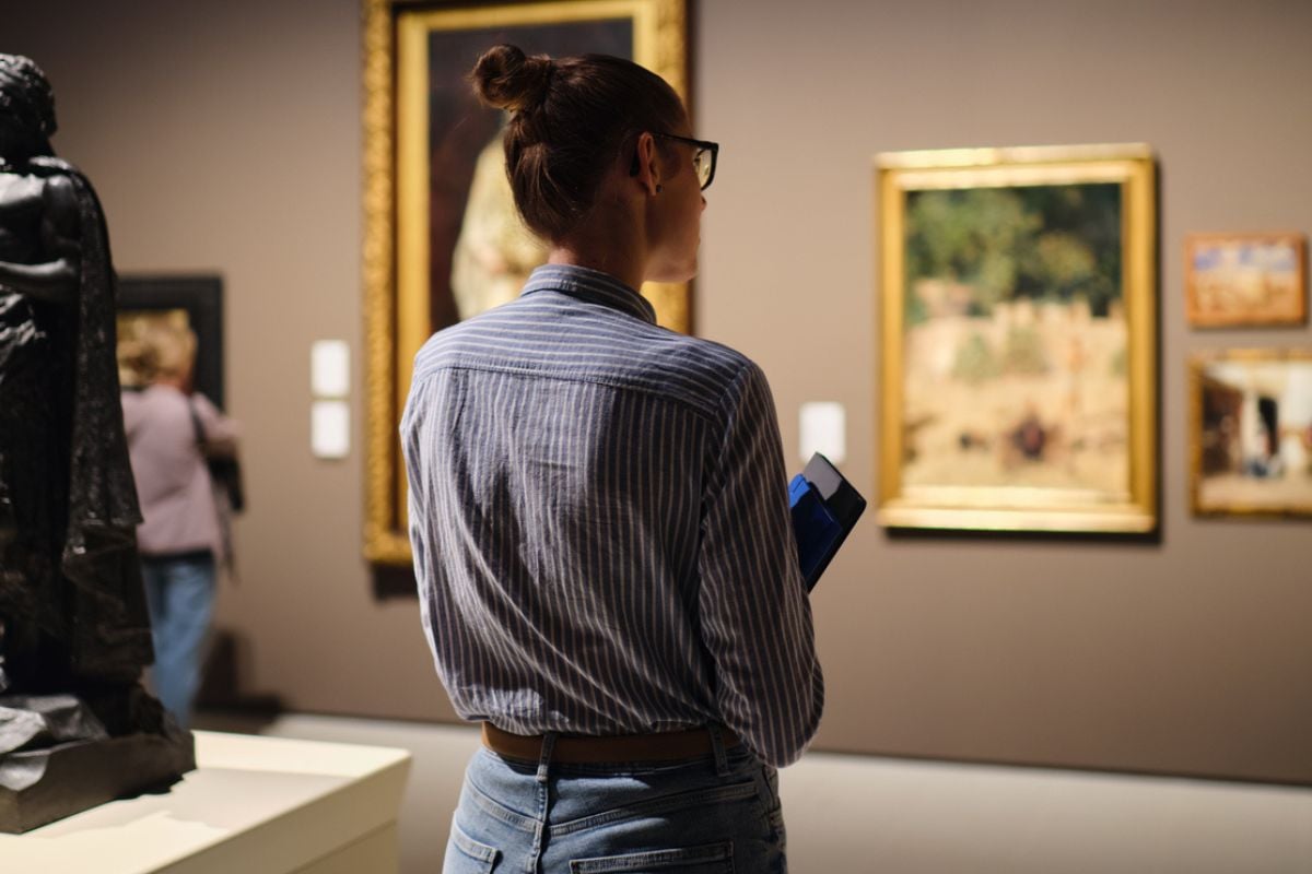 Visitor in historical museum looking at art object